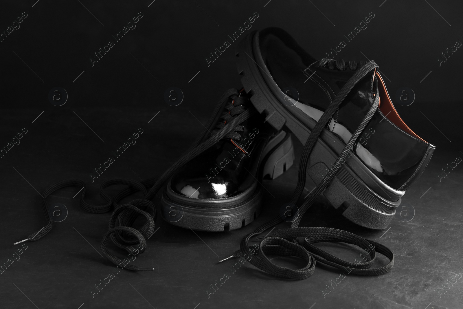 Photo of Pair of stylish shoes with laces on black background