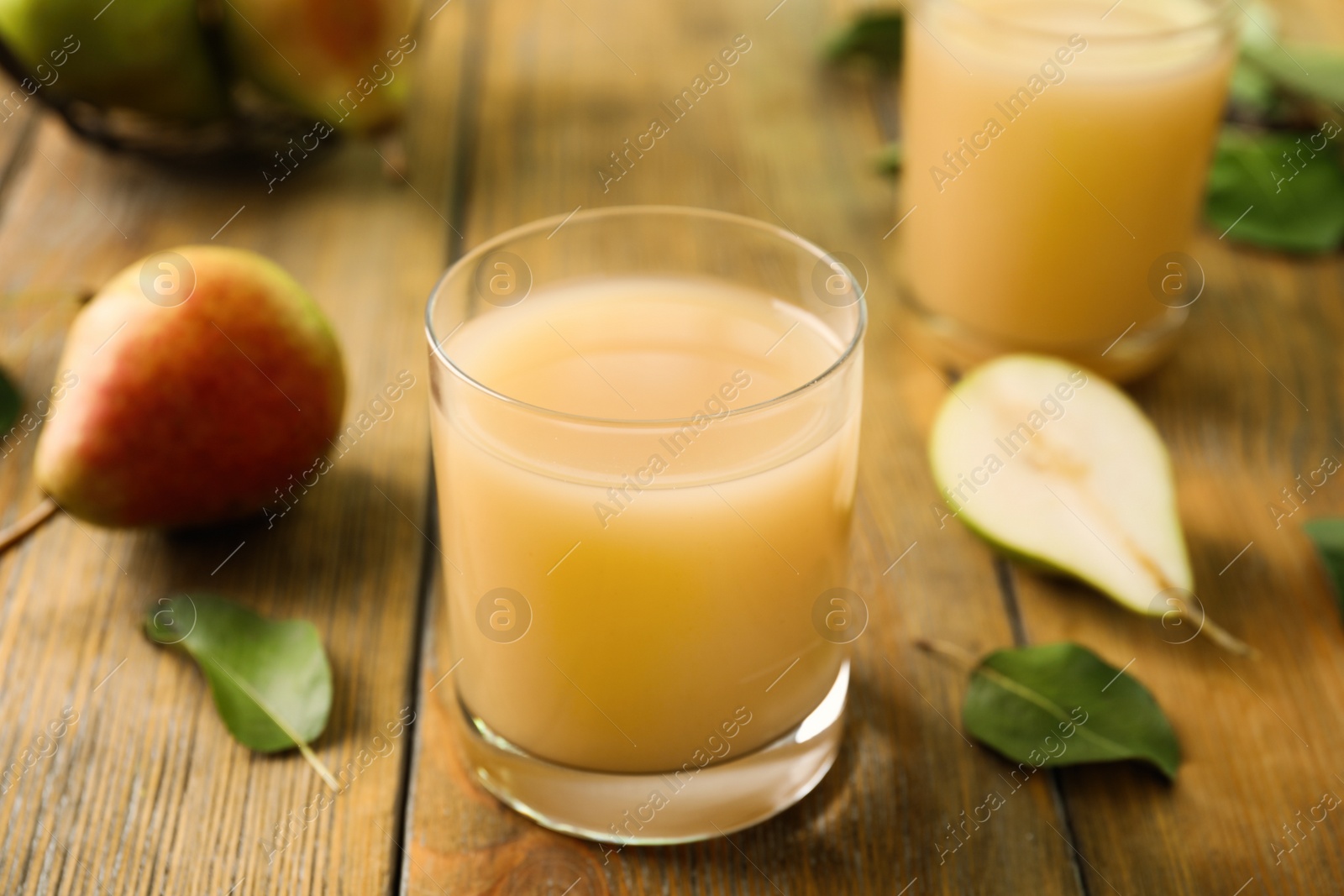 Photo of Fresh pear juice in glass on wooden table, closeup