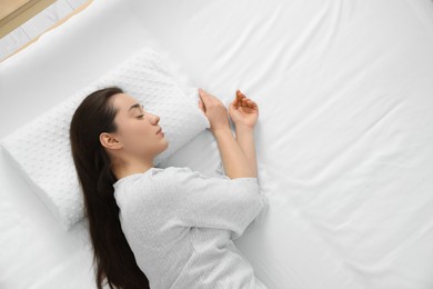 Photo of Woman sleeping on memory foam pillow, top view. Space for text