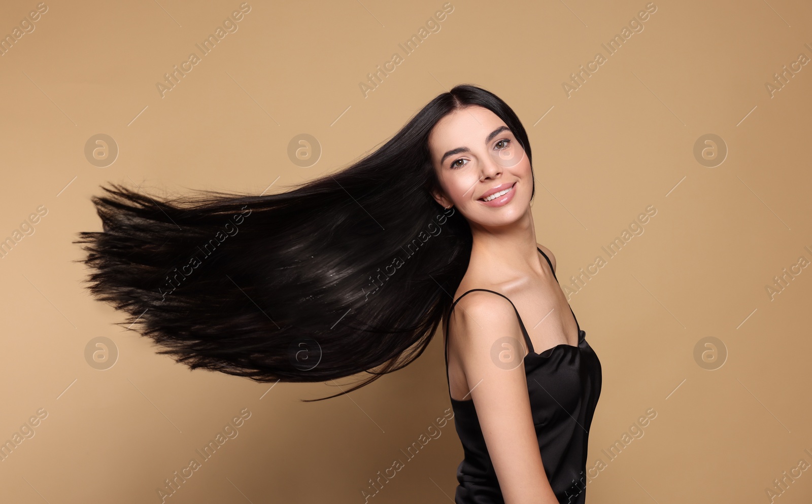 Photo of Portrait of beautiful young woman with healthy strong hair on beige background