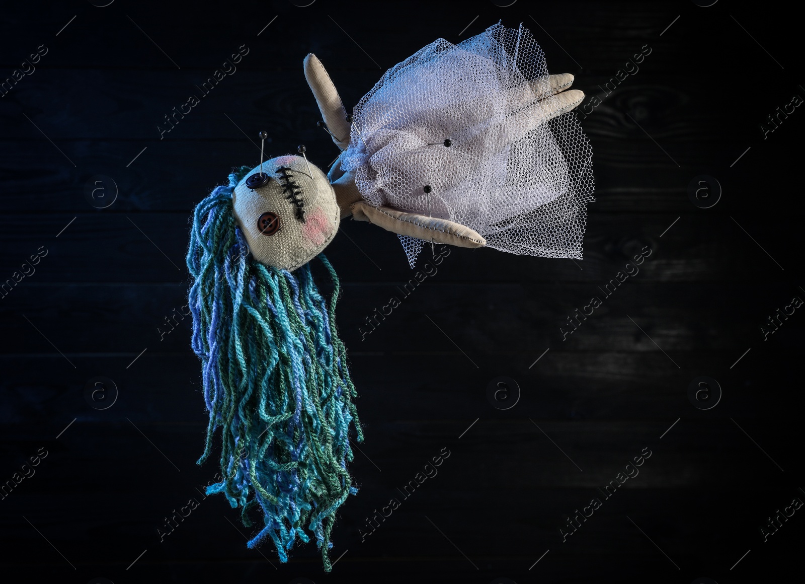 Photo of Female voodoo doll with pins on dark background