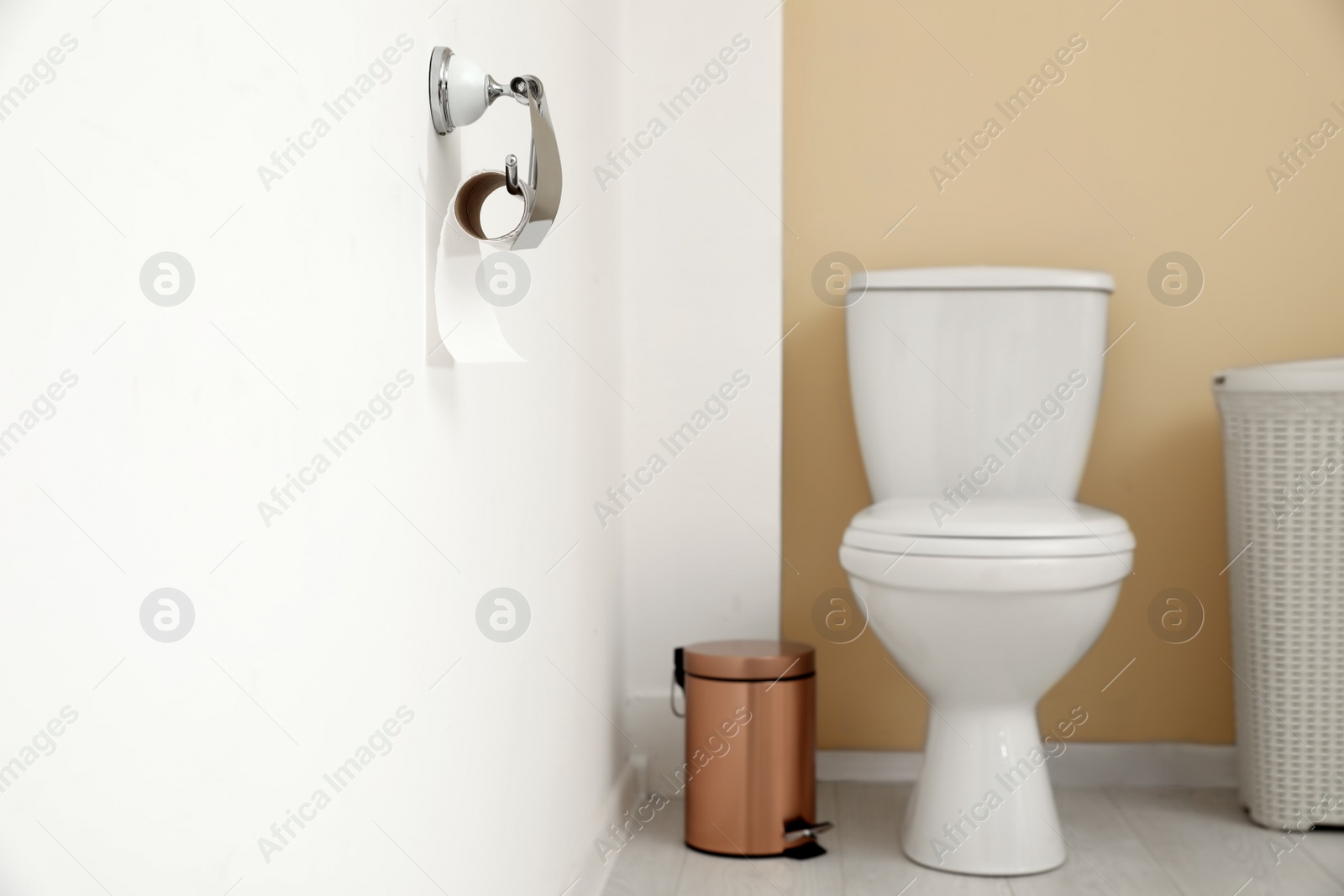 Photo of Holder with toilet paper roll on wall in bathroom