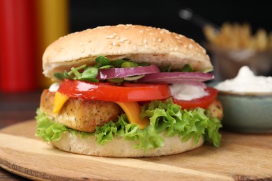 Photo of Delicious burger with tofu and fresh vegetables on wooden board, closeup