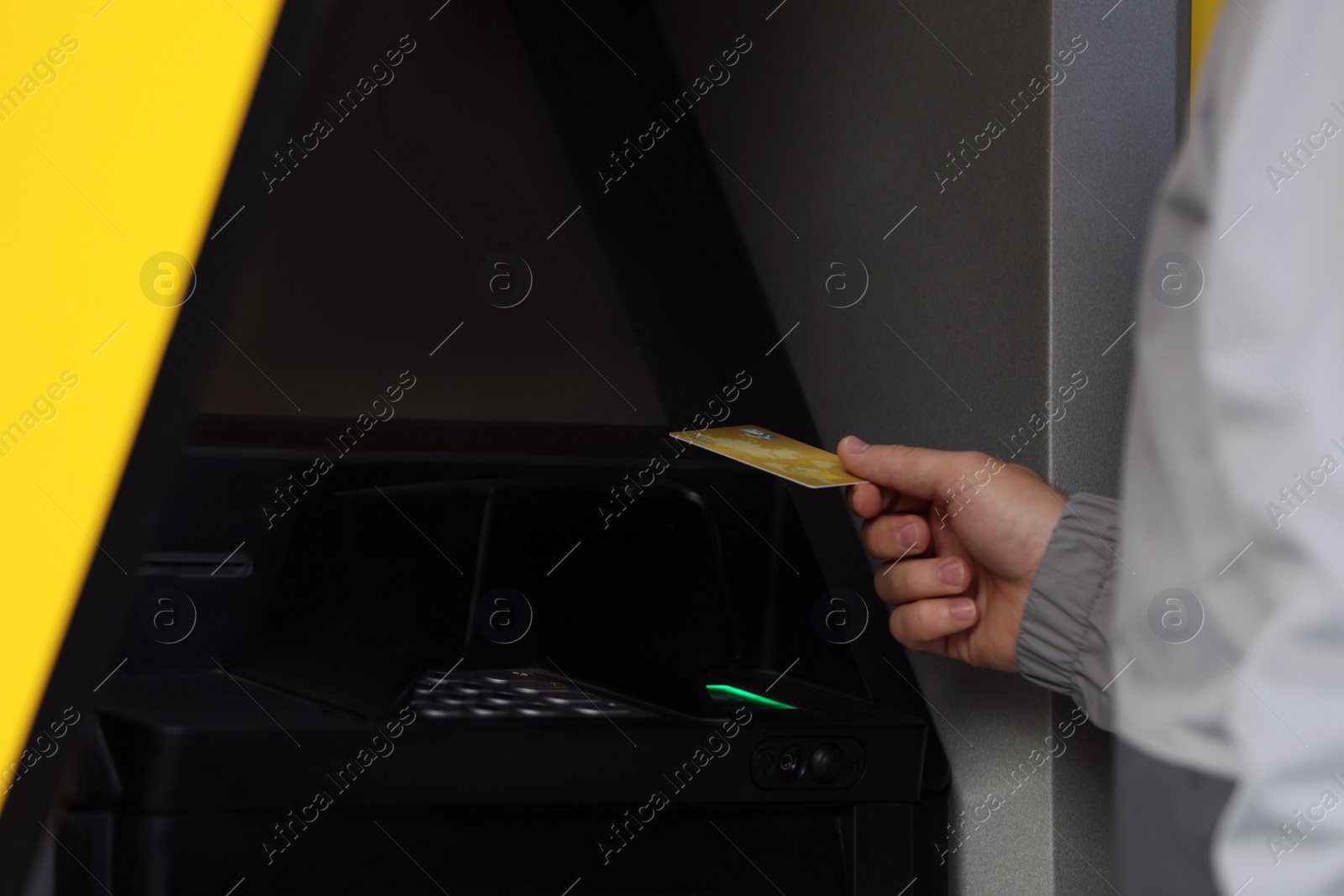 Photo of Man with debit card using cash machine for money withdrawal outdoors, closeup