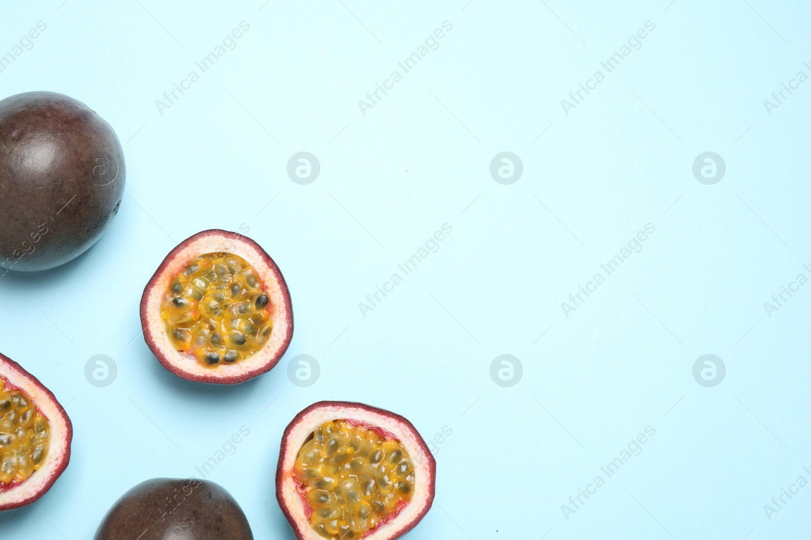 Photo of Fresh ripe passion fruits (maracuyas) on light background, flat lay. Space for text