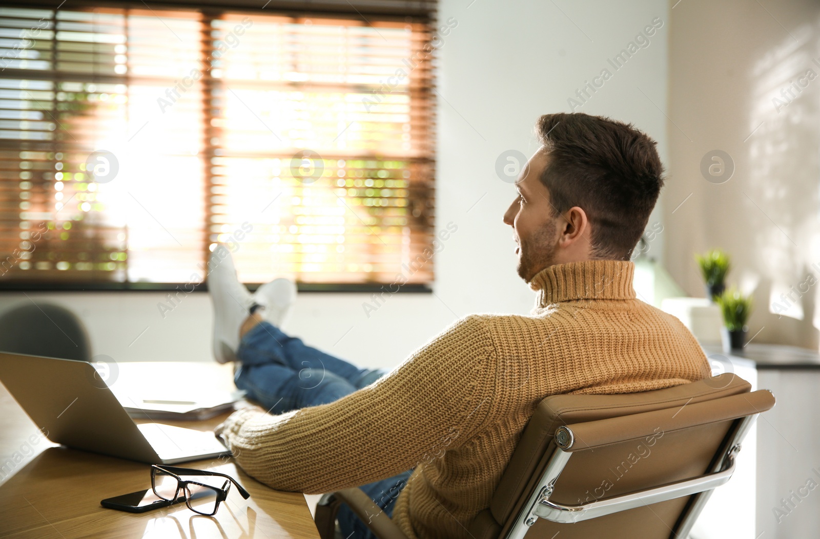 Photo of Young man relaxing at desk in office