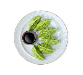 Photo of Delicious green dumplings (gyozas) and soy sauce isolated on white, top view