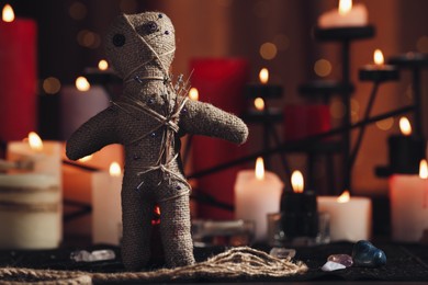 Photo of Voodoo doll with pins and dried flowers on table in room, space for text. Curse ceremony