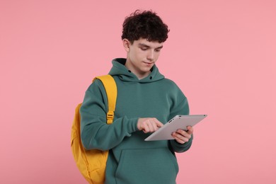 Photo of Portrait of student with backpack and tablet on pink background