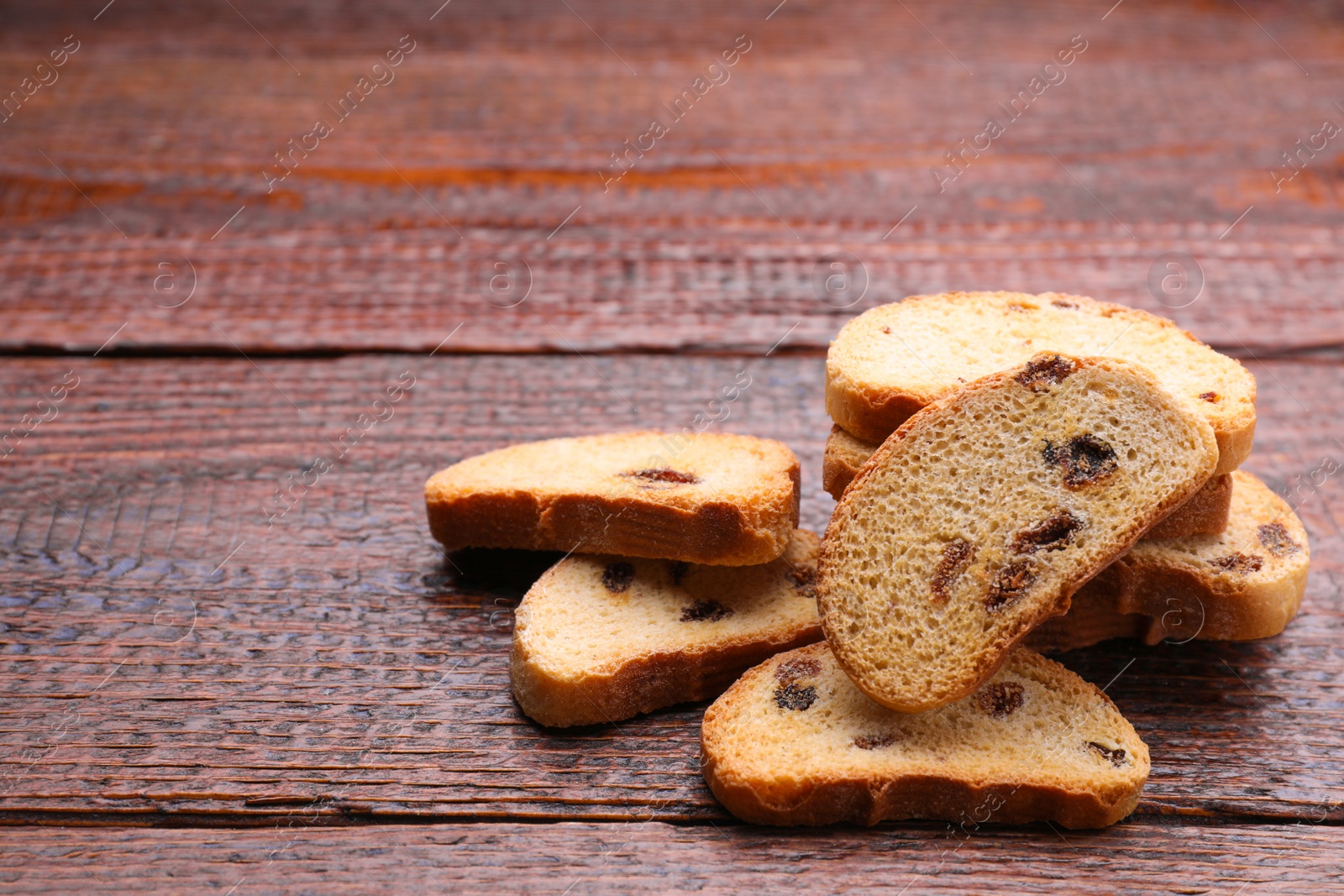 Photo of Sweet hard chuck crackers with raisins on wooden table. Space for text