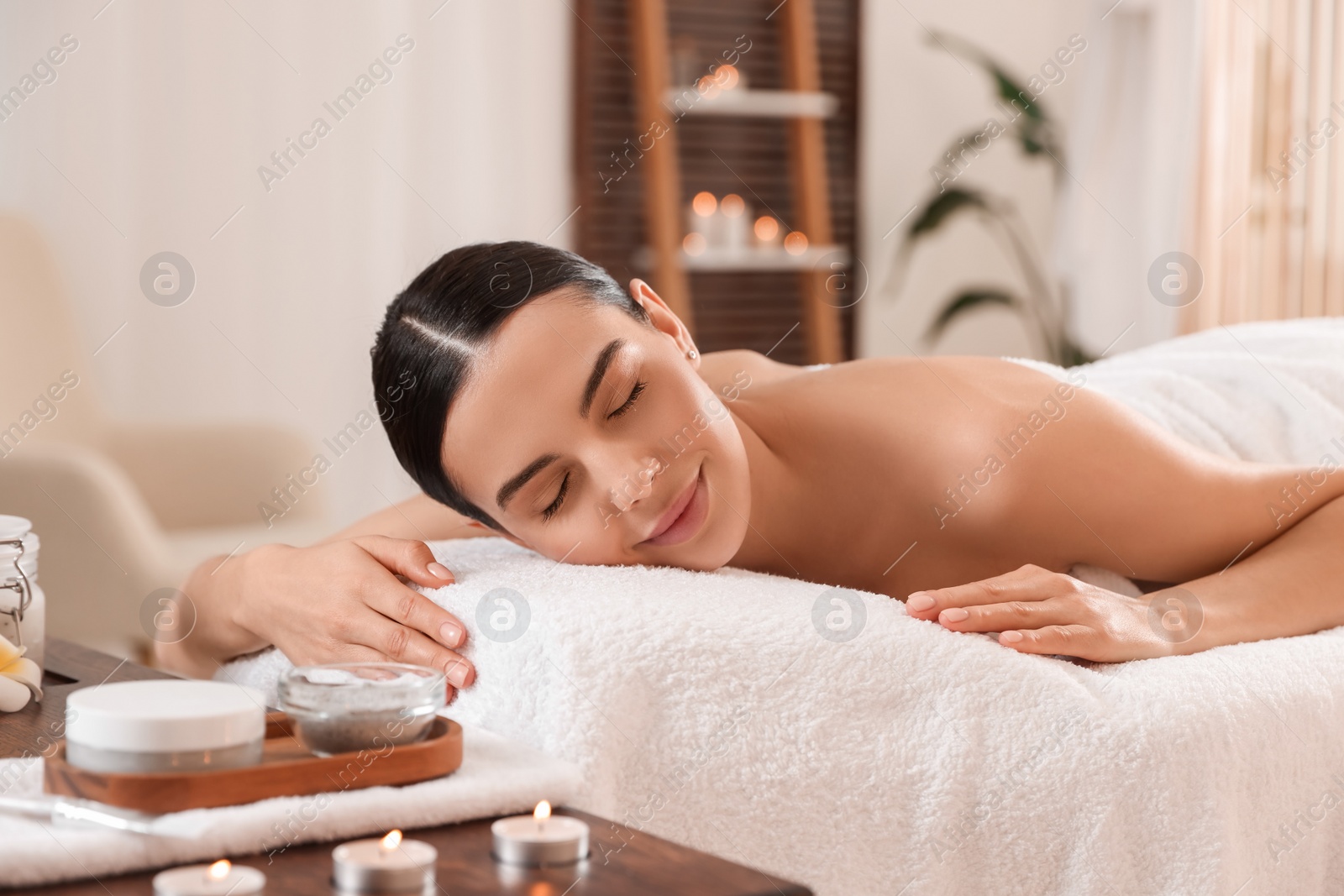 Photo of Young woman resting on massage couch in spa salon