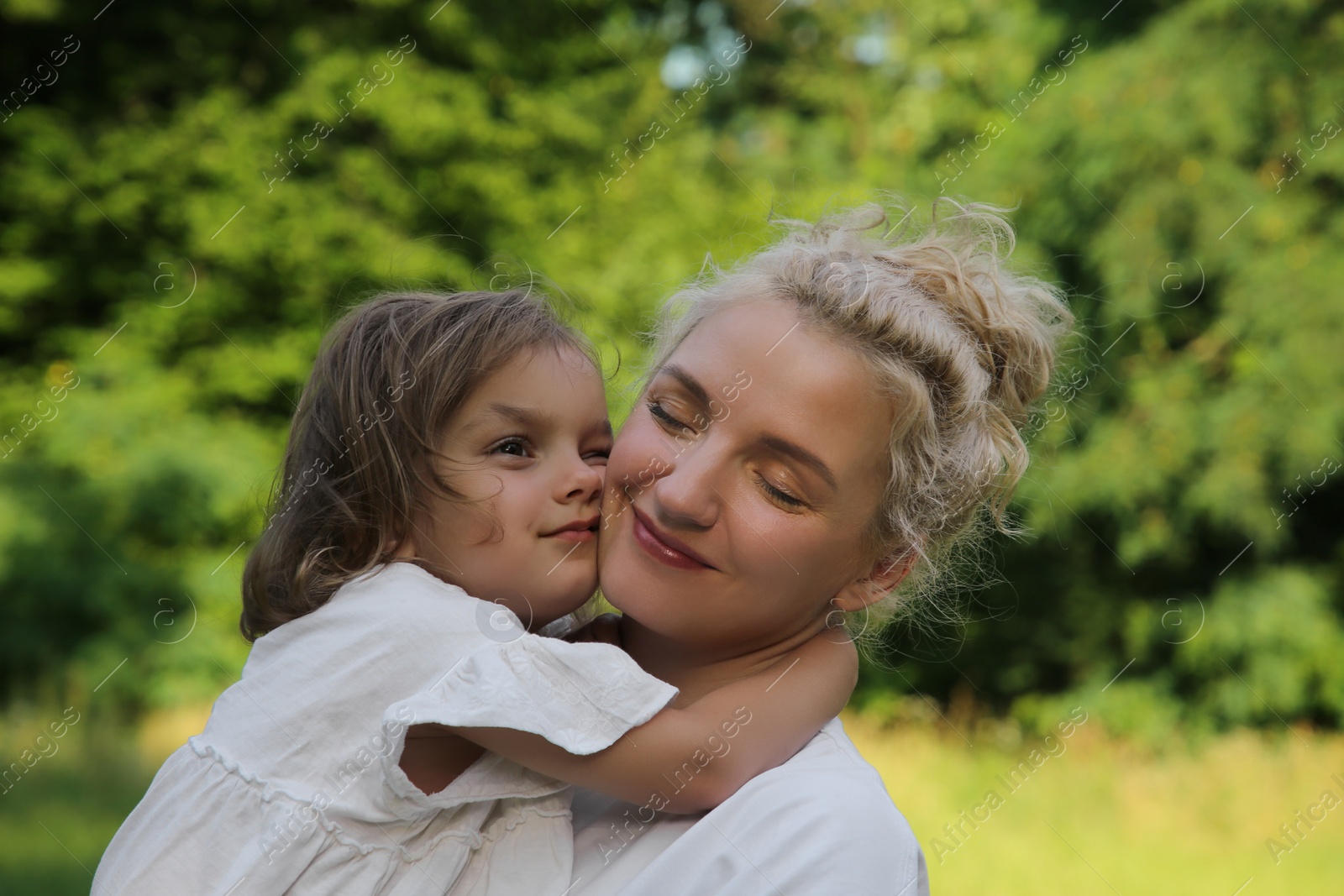 Photo of Portrait of beautiful mother with her cute daughter outdoors