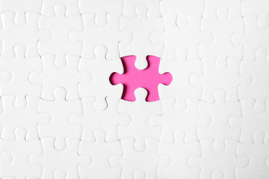 Photo of Blank white puzzle with missing piece on pink background, top view