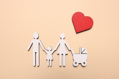 Photo of Figures of family and heart on beige background, top view. Insurance concept