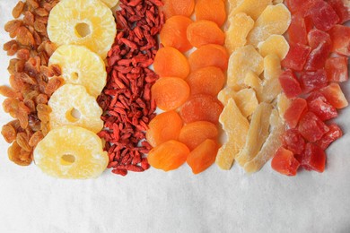 Photo of Different tasty dried fruits on paper, flat lay