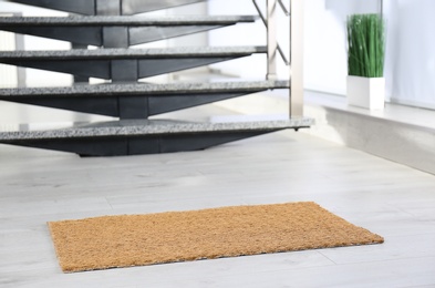 Photo of New door mat near stone stairs indoors