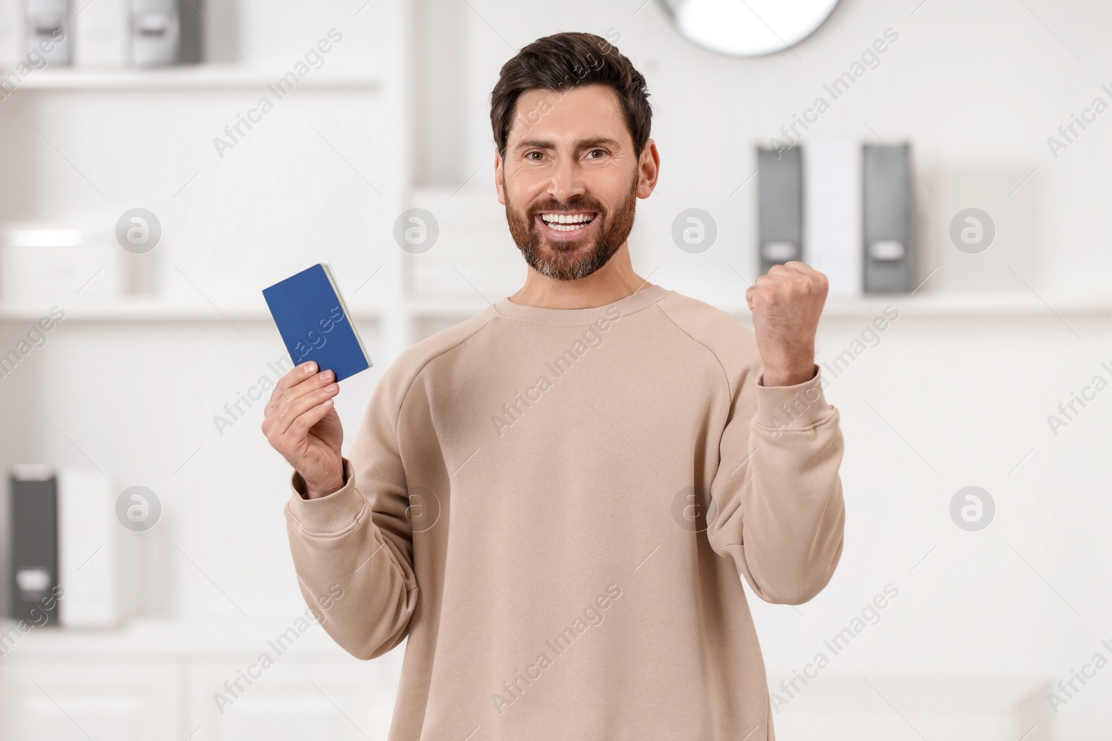 Photo of Immigration. Portrait of happy man with passport indoors