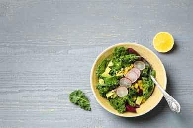 Delicious kale salad served on grey wooden table, flat lay. Space for text