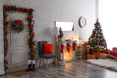 Photo of Stylish interior with beautiful Christmas tree and decorative fireplace