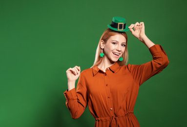 Photo of Young woman in leprechaun hat on green background, space for text. St. Patrick's Day celebration