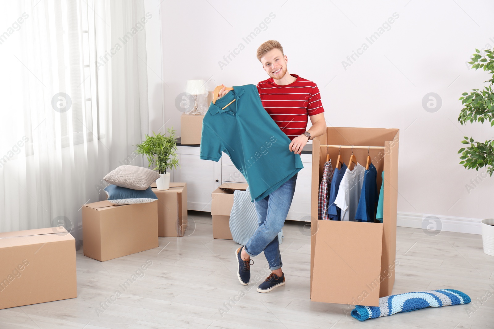 Photo of Young man near wardrobe box at home