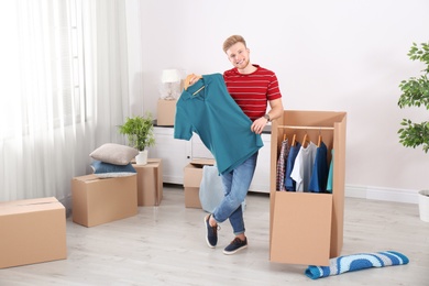 Young man near wardrobe box at home