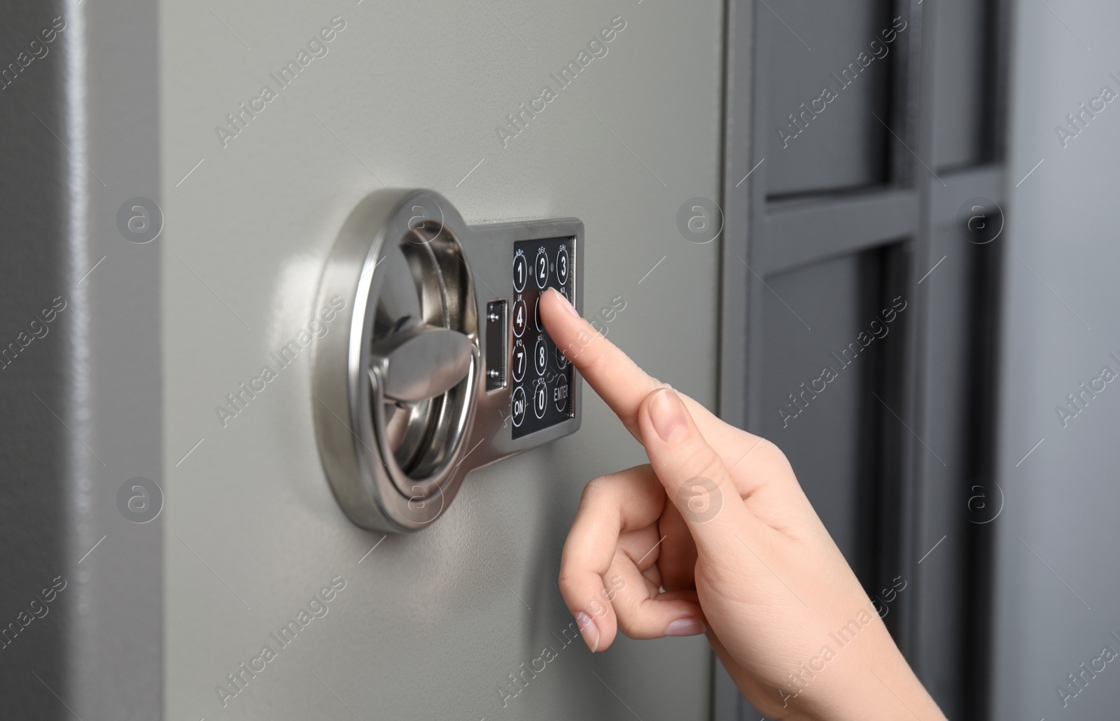 Woman opening steel safe with electronic lock, closeup Photo of Woman opening steel safe with electronic lock, closeup
