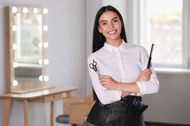 Photo of Portrait of happy hairdresser with professional tools in beauty salon, space for text