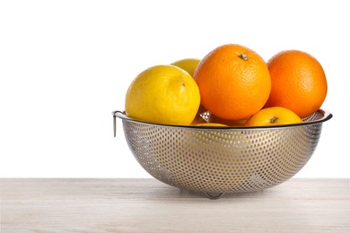 Photo of Fresh fruits in colander on wooden table against white background. Space for text