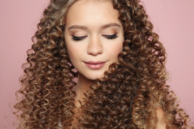 Photo of Portrait of beautiful young woman with shiny wavy hair on color background, closeup