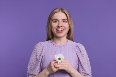 Photo of Beautiful woman with spring flower in hands on purple background