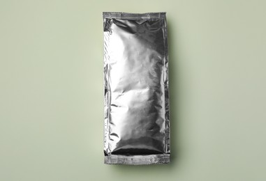 Photo of Blank foil package on light background, top view