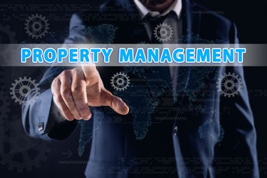Image of Property management concept. Man using virtual screen with gear images, closeup