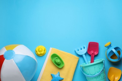 Photo of Flat lay composition with beach ball and sand toys on light blue background, space for text