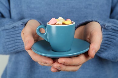 Photo of Woman holding cup of delicious hot chocolate with marshmallows, closeup
