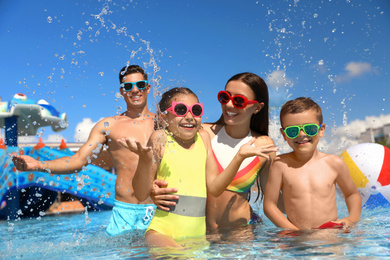 Photo of Happy family having fun at water park. Summer vacation