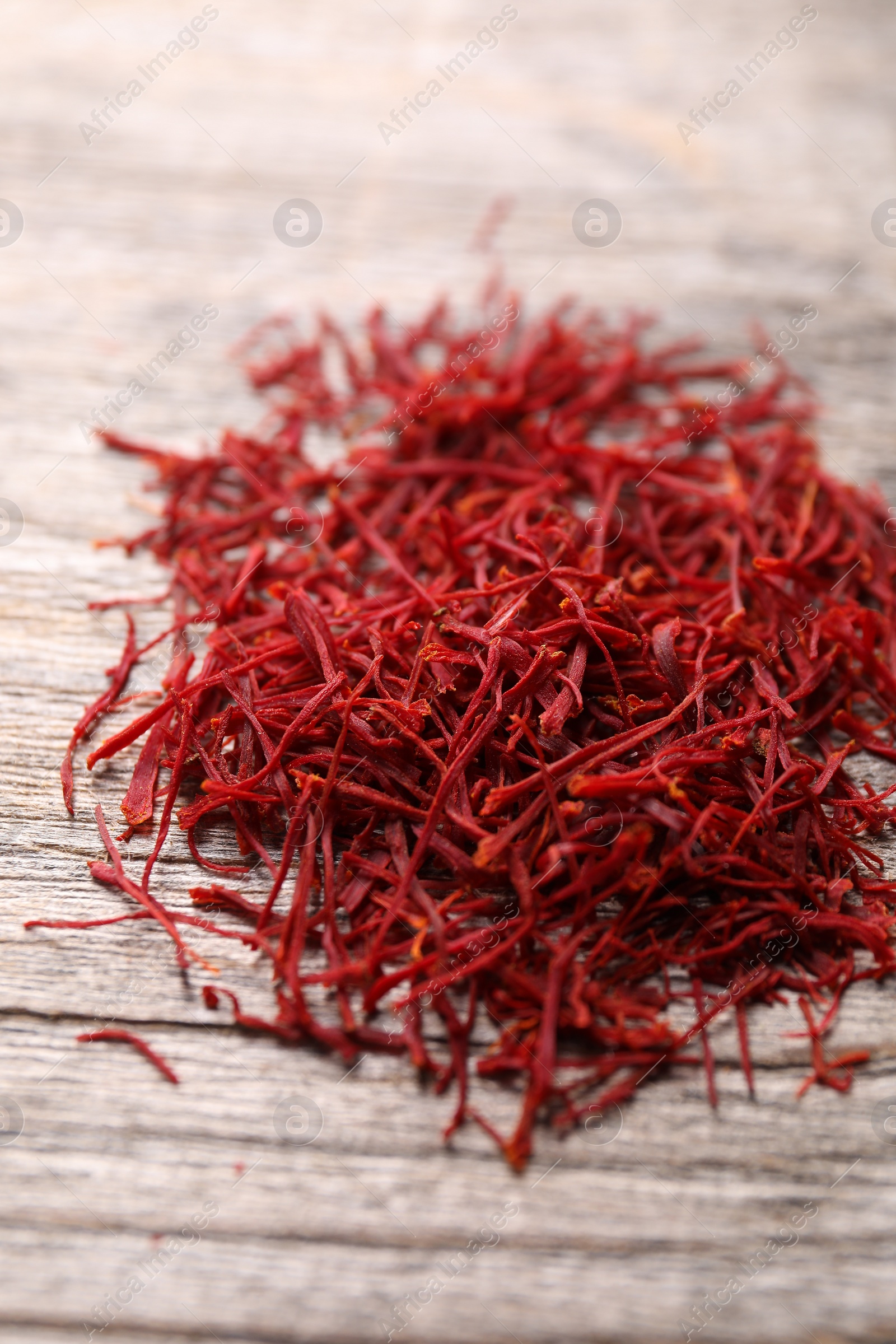 Photo of Aromatic saffron on wooden table, closeup view