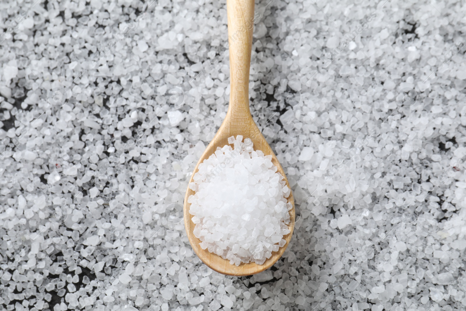 Photo of Natural salt and wooden spoon, top view