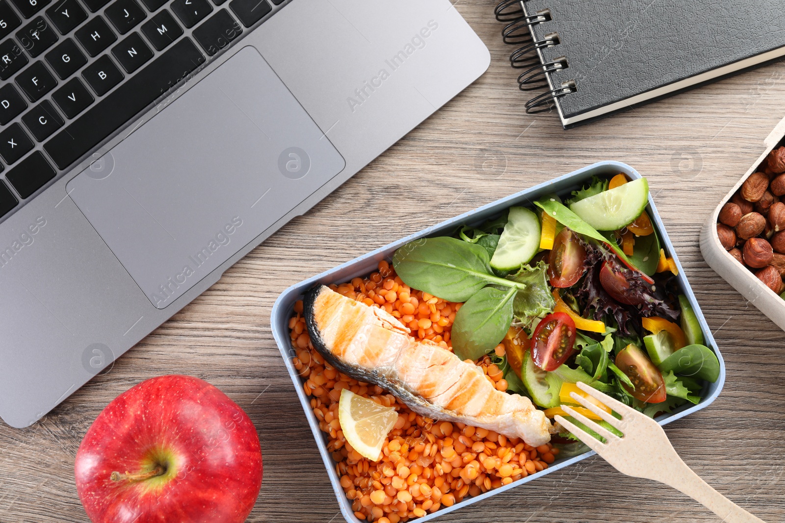 Photo of Healthy products high in vegetable fats near laptop on wooden table, flat lay