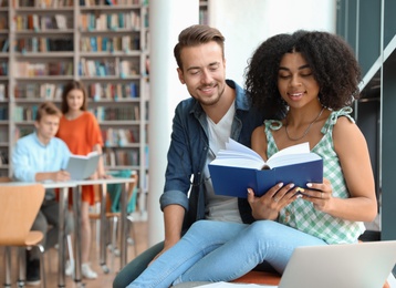 Photo of Young people studying together in modern library
