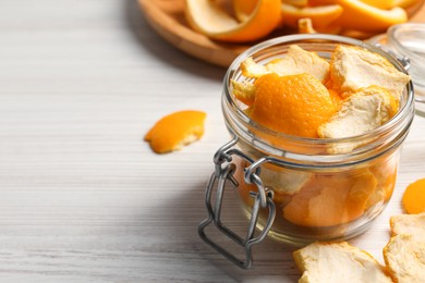 Photo of Orange peels preparing for drying on white wooden table, closeup. Space for text