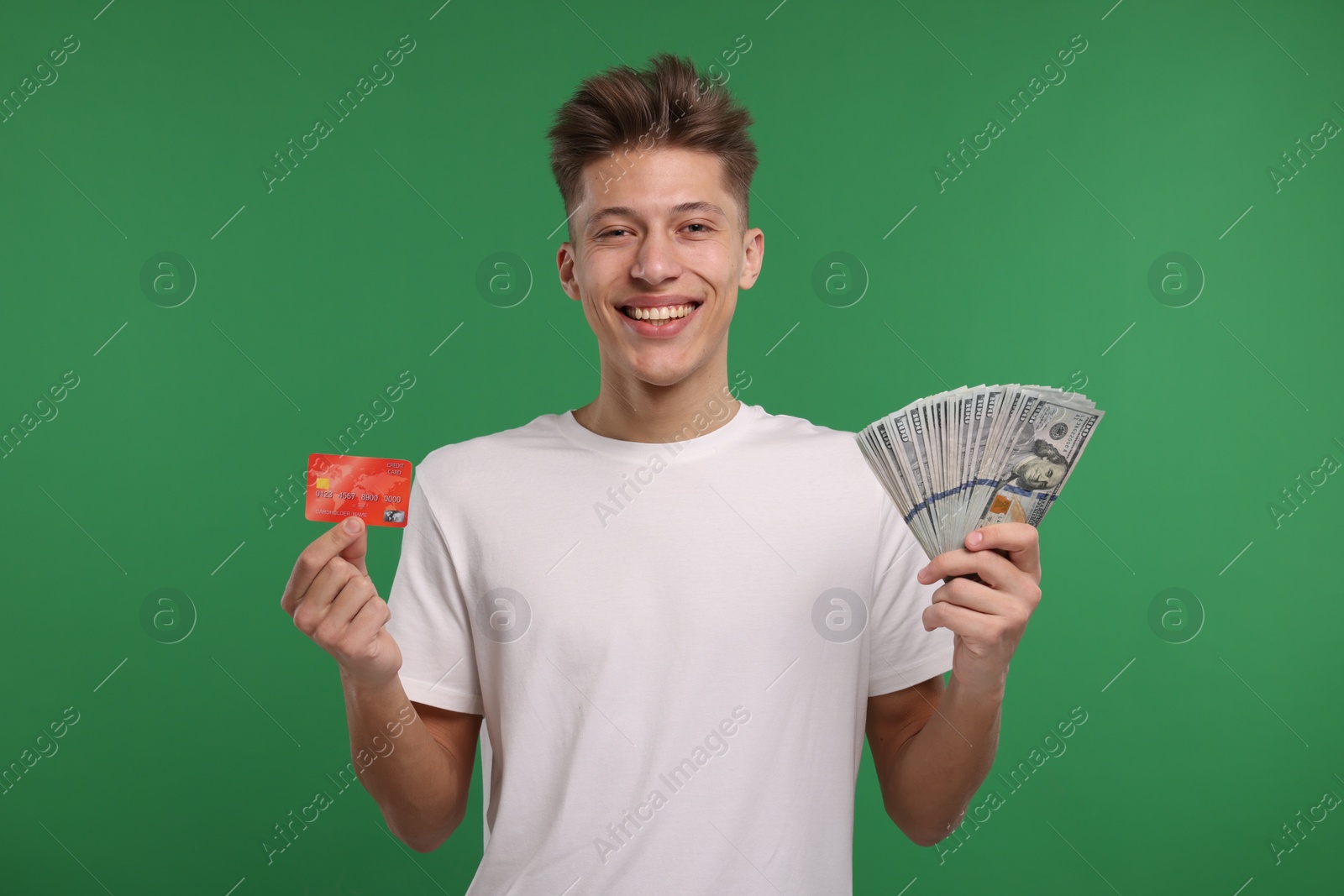 Photo of Happy man with credit card and dollar banknotes on green background