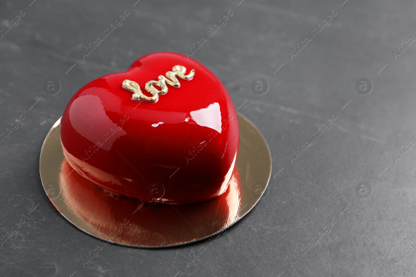 Photo of St. Valentine's Day. Delicious heart shaped cake on black table, closeup. Space for text