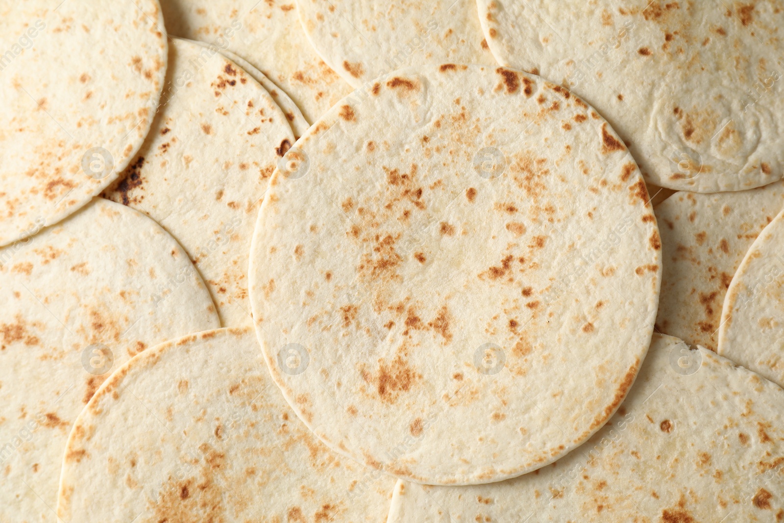 Photo of Many tasty homemade tortillas as background, top view