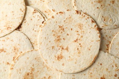 Many tasty homemade tortillas as background, top view