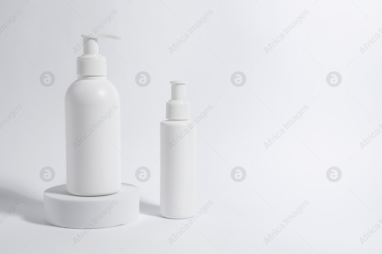 Photo of Bottles with cosmetic products on white background, space for text