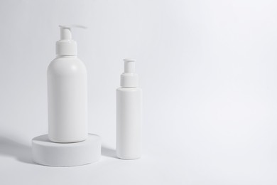 Bottles with cosmetic products on white background, space for text