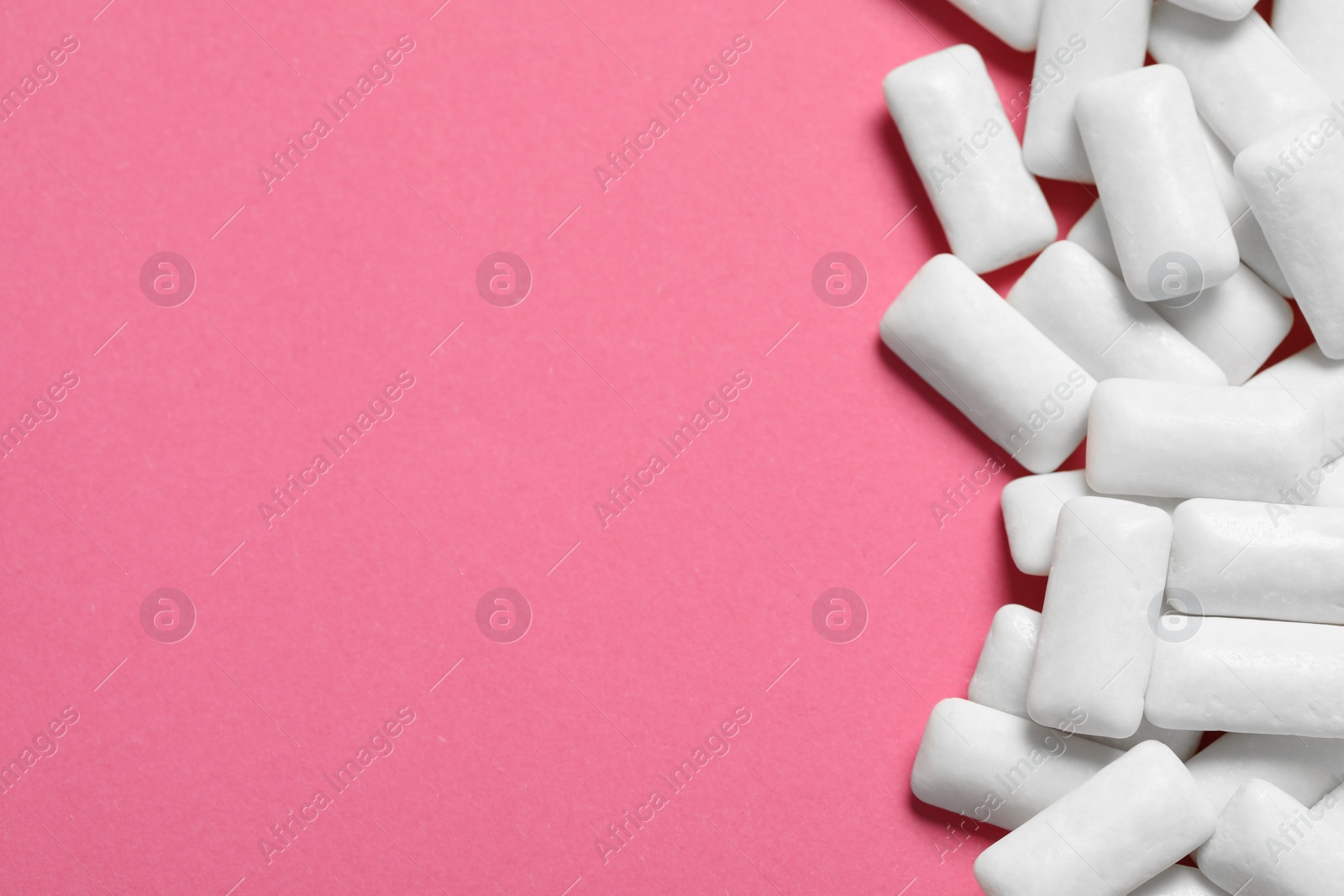 Photo of Tasty white chewing gums on pink background, top view. Space for text