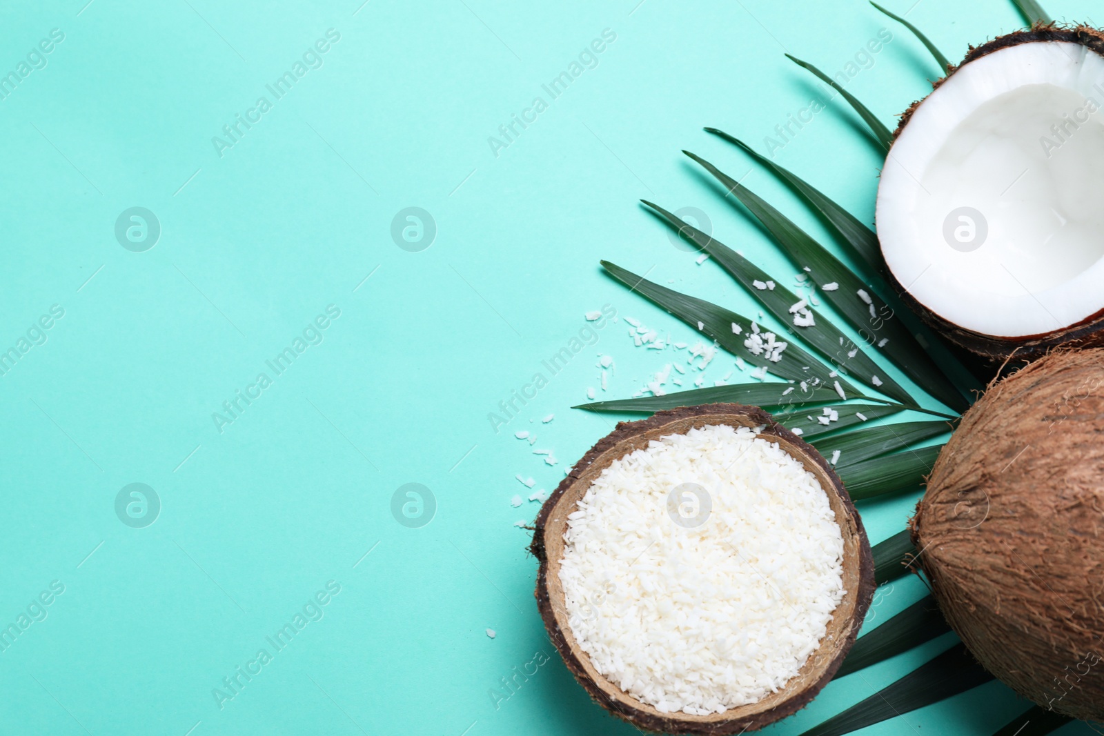 Photo of Flat lay composition with fresh coconut flakes on turquoise background. Space for text