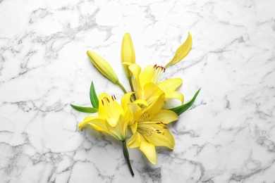 Photo of Flat lay composition with beautiful blooming lily flowers on marble background